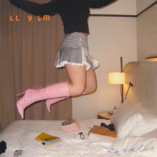 A bedroom with a woman seen wearing pink boots jumping on the bed where there are various objects on it. Rosalía's name is written in blue ink on the bottom with the album's title on the top left, resembling a date stamp.