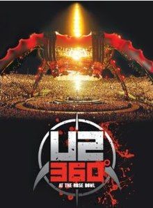 A tour stage; four large legs curve up above the stage and hold a circular video screen above the band. The legs are lit up in red and a spire that runs through the center of the stage illuminates the audience with yellow light. A grey circle is drawn below the photograph with the words U2 360° at the Rose Bowl written in the center; 360° is written in red, and the rest is written in grey. Two claws extend downwards in either side, representing a stylized drawing of the stage.