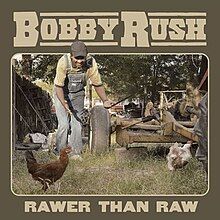 Bobby Rush, wearing overalls in a farmyard