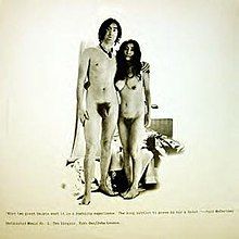 Jon Lennon and Yoko Ono frontally nude, Lennon’s arm around Ono. The couple are in the center of the cover, which is mostly blank off-white except for some small text.