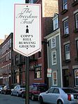 A Freedom Trail sign on Copp's Hill in the North End with the Skinny House in the background