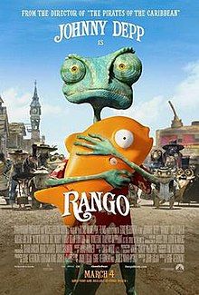 Rango, a green chameleon, holding Mr. Timms, a large plastic orange fish, in old west town, Dirt.