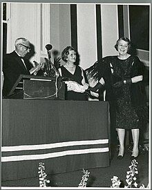 Photograph of reception and presentation on Michael Tierney's retirement as President of UCD : Presentation of a bouquet of flowers to Eibhlín Tierney (centre) by Carmel Humphries (on the right).