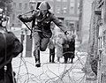 East German border guard Konrad Schumann leaping over barbed wire to defect to West Germany, 1961