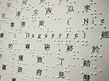 Rows of standard Mandarin interlaced with rows of Braille