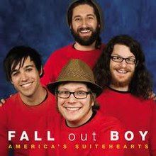 A portrait of the band members smiling on a blue background, each wearing red sweaters. The band name is written in white, and the song title is written below in yellow.