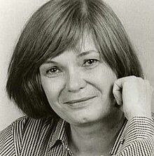 Black and white publicity shot of a smiling young woman with no apparent makeup, shoulder-length, straight dark hair, and a striped shirt