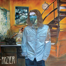 A painting of a auburn-haired man who wears a light blue shirt and blue jeans is standing beside a room. His face and left shoulder are covered by two different paintings and the word "Hozier", stylized in all capital letters, is placed on the lower left corner of the picture.