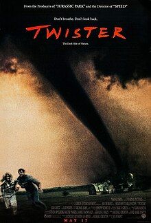 The dark storm funnel of a Twister against a pale sky, destroying a barn. Two small figures flee in the foreground.