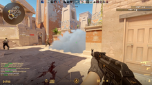 Screenshot from Counter-Strike 2, demonstrating gameplay from the Terrorist side on the map Anubis. The player in the image, who is observing a volumetric smoke cloud, is holding an AK-47 assault rifle.