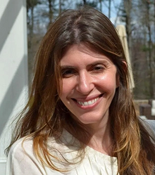 A smiling Caucasian woman with shoulder-length brown hair