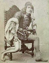 man in 16th century costume sitting in chair