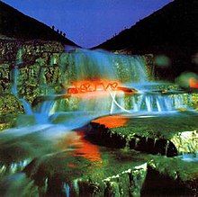 A close up of a waterfall with a neon sign that reads "Verve"